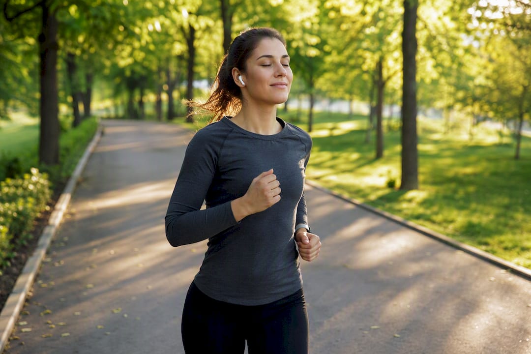 Person joggt draußen und hört Musik mit Kopfhörern